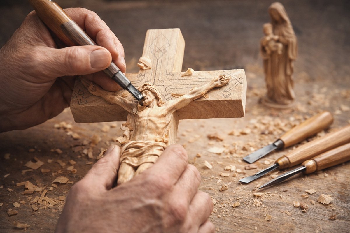 woodcarver shaping details of a Christian icon using fine carving tools